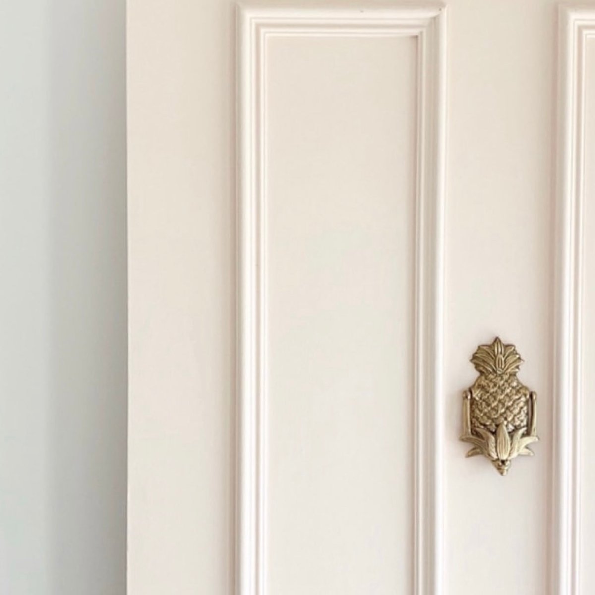 Gold pineapple door knocker on door by Ocean Luxe