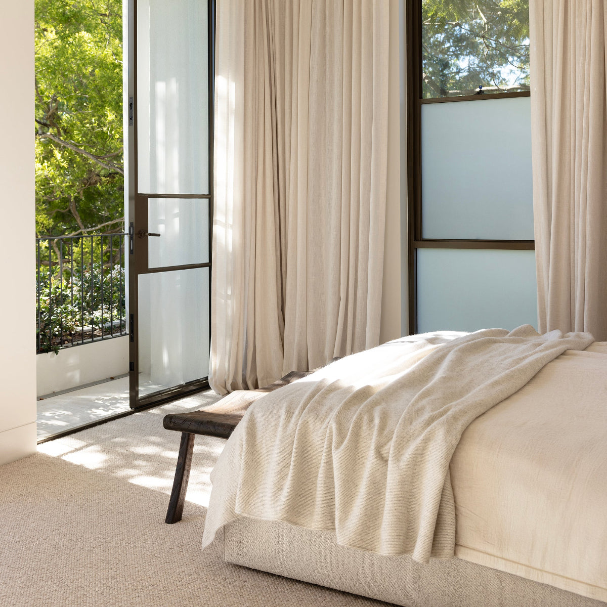 Modern bedroom with large windows and neutral decor