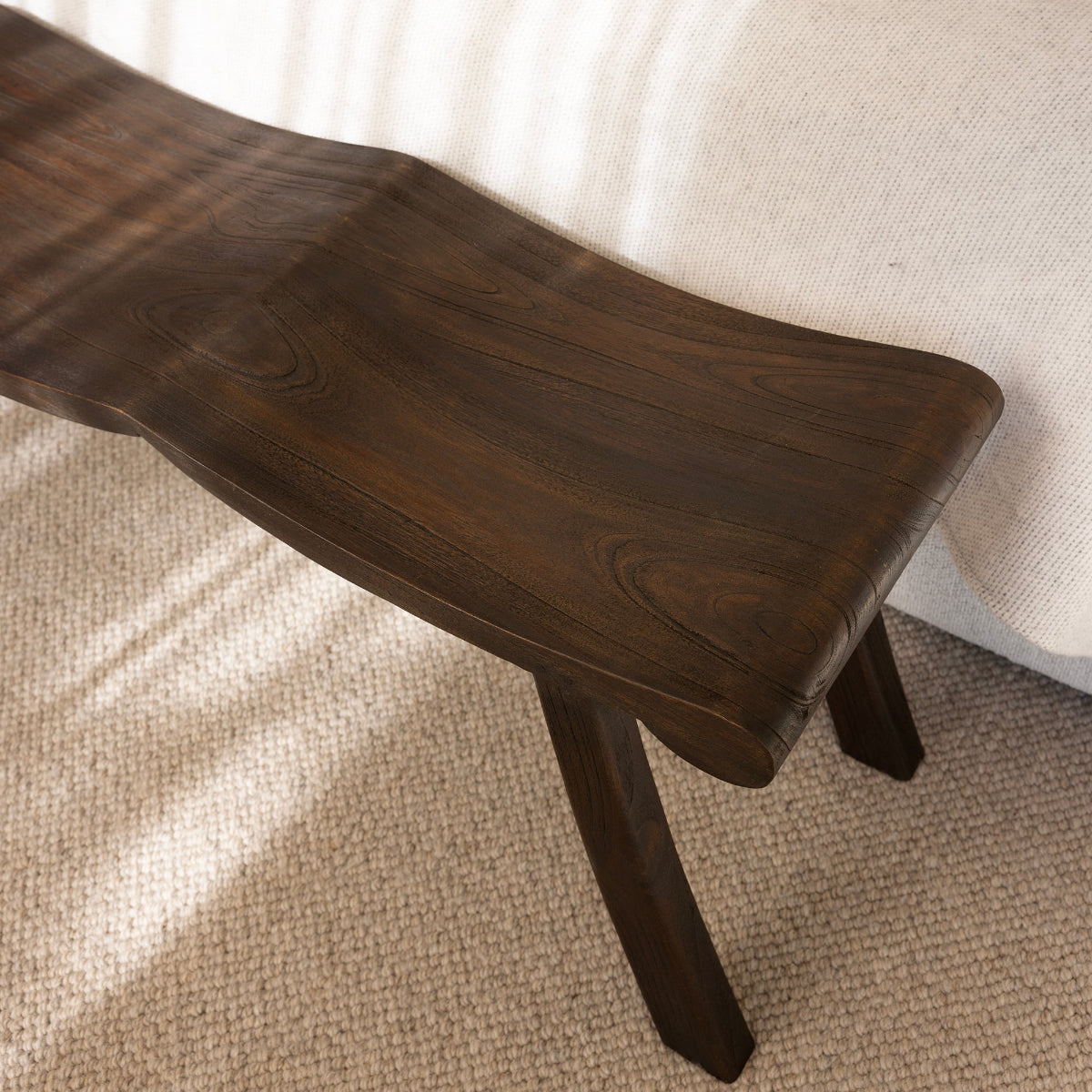 Wooden bench in front of a bed with white bedding